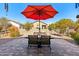 Relaxing backyard patio with table, chairs, and umbrella; perfect for outdoor dining at 22402 W Harrison St, Buckeye, AZ 85326