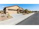 Tan house with a two-car garage and desert landscaping at 22402 W Harrison St, Buckeye, AZ 85326