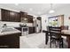 Kitchen with dark brown cabinets, granite counters and stainless steel appliances at 22402 W Harrison St, Buckeye, AZ 85326