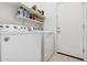 Laundry room with washer, dryer, and storage shelves at 22402 W Harrison St, Buckeye, AZ 85326