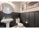 Stylish powder room with pedestal sink and dark-colored wainscoting at 23071 N 98Th Dr, Peoria, AZ 85383