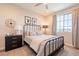 Bedroom with metal bed frame, nightstand, and large window at 23071 N 98Th Dr, Peoria, AZ 85383