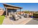 Covered outdoor kitchen with seating and a fire pit area at 23071 N 98Th Dr, Peoria, AZ 85383