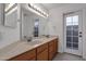 Bathroom with double vanity, large mirror, and access to backyard at 23827 N 44Th Ln, Glendale, AZ 85310