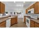 Kitchen with wood cabinets, white appliances, and a breakfast bar at 23827 N 44Th Ln, Glendale, AZ 85310