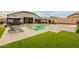 This backyard has a luxurious pool, spa, artificial grass, and two shade structures for lounging and outdoor entertaining at 23933 N 167Th Ln, Surprise, AZ 85387