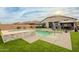 View of the backyard featuring a pristine pool, inviting spa, lush artificial grass, and shaded relaxation areas at 23933 N 167Th Ln, Surprise, AZ 85387