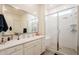 Modern bathroom featuring a glass-enclosed shower and large vanity mirror at 23933 N 167Th Ln, Surprise, AZ 85387