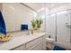 Modern bathroom with quartz countertops, framed mirror, glass shower, and neutral color palette at 23933 N 167Th Ln, Surprise, AZ 85387