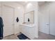 Clean, white bathroom featuring a vanity with double doors, large mirror, and tile flooring at 23933 N 167Th Ln, Surprise, AZ 85387