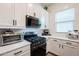 This kitchen features white cabinets, quartz countertops, black hardware and appliances at 23933 N 167Th Ln, Surprise, AZ 85387