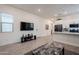 Bright living room featuring a large TV, neutral walls, and an opening into the kitchen area at 23933 N 167Th Ln, Surprise, AZ 85387