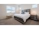 Brightly lit main bedroom featuring a large window, carpet flooring and a large bed at 23933 N 167Th Ln, Surprise, AZ 85387