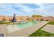 Beautiful pool and spa with a waterfall feature, surrounded by green lawn and lounge chairs at 23933 N 167Th Ln, Surprise, AZ 85387