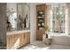 Bright bathroom with marble countertops, wood cabinets, tall cabinet and stand alone tub by bright windows at 27545 N 97Th Pl, Scottsdale, AZ 85262