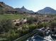 Scenic view of a golf course and mountain range from a backyard, including a glimpse of the pool and patio at 27545 N 97Th Pl, Scottsdale, AZ 85262