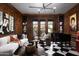 Sophisticated living room with dark wood paneling, checkerboard floors, and stylish contemporary furnishings at 27545 N 97Th Pl, Scottsdale, AZ 85262