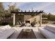 Inviting outdoor space with a pergola, stone fireplace, and stylish seating, perfect for relaxation and entertaining at 27545 N 97Th Pl, Scottsdale, AZ 85262