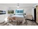 Comfortable main bedroom with wood-look flooring, a TV, seaside themed decor, and an accent chair at 2912 E Clarendon Ave, Phoenix, AZ 85016