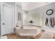 Bright bathroom featuring a soaking tub with marble surround and glass block partition at 2939 E Huber St, Mesa, AZ 85213