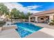 Backyard with a large swimming pool, stone fireplace, outdoor seating, and covered patio area at 2939 E Huber St, Mesa, AZ 85213