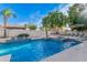 Lush backyard with a pool featuring water features and an outdoor fireplace and seating area at 2939 E Huber St, Mesa, AZ 85213