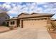 Tan two-story house with a three-car garage and desert landscaping at 29590 N Balmoral Pl, San Tan Valley, AZ 85143