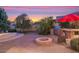 Outdoor kitchen, fire pit, and seating area in a beautifully landscaped backyard at 3447 E Kenwood St, Mesa, AZ 85213