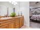 Double vanity bathroom with wood cabinets and a view to bedroom at 3447 E Kenwood St, Mesa, AZ 85213