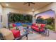 Relaxing covered patio with seating area overlooking the pool and beautiful sunset at 3447 E Kenwood St, Mesa, AZ 85213