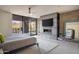 Modern main bedroom with fireplace, large TV, and sliding glass doors leading to patio at 38484 N 94Th St, Scottsdale, AZ 85262