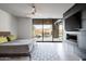 Luxurious main bedroom with fireplace, large TV, and sliding glass doors leading to patio at 38484 N 94Th St, Scottsdale, AZ 85262