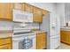 White appliances and wood cabinets in this well-lit kitchen at 3936 E Ascot Dr, San Tan Valley, AZ 85140