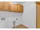 Bright laundry room with wood cabinets and tile floor at 3936 E Ascot Dr, San Tan Valley, AZ 85140