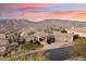 Expansive aerial view showcasing the property's tile roof, three-car garage, and mountain views at 402 E Windmere Dr, Phoenix, AZ 85048