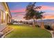 Stunning backyard at dusk with lush lawn, mountain views, and colorful sunset at 402 E Windmere Dr, Phoenix, AZ 85048