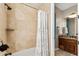 Elegant bathroom featuring a bathtub with a shower, tiled walls, and a glimpse into the vanity area at 402 E Windmere Dr, Phoenix, AZ 85048