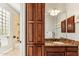 Bathroom featuring wood cabinets, granite countertops, a large mirror, and a bath/shower combination at 402 E Windmere Dr, Phoenix, AZ 85048