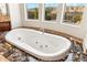 Close up of the jacuzzi bathtub with marble countertop and mountain views from the window at 402 E Windmere Dr, Phoenix, AZ 85048