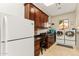 Spacious laundry room with wood cabinets, desk, utility sink, and washer and dryer at 402 E Windmere Dr, Phoenix, AZ 85048