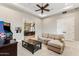 This living room has an arcade game, neutral walls, carpet, and a ceiling fan at 402 E Windmere Dr, Phoenix, AZ 85048