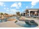 A luxury pool with a rock waterfall, lush landscaping, and beautiful mountain views at 402 E Windmere Dr, Phoenix, AZ 85048