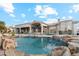 Luxury pool with a rock waterfall, lush landscaping, and mountain views at 402 E Windmere Dr, Phoenix, AZ 85048