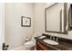 Stylish powder room with granite countertop, decorative mirror, and neutral wall color at 402 E Windmere Dr, Phoenix, AZ 85048