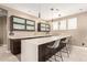 Elegant wet bar with dark wood cabinetry and a quartz countertop at 4176 E Glacier Pl, Chandler, AZ 85249