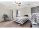 Bedroom with striped bedding, ceiling fan and adjacent bathroom at 4322 E Whitehall Dr, San Tan Valley, AZ 85140