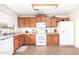 Bright kitchen with oak cabinets, white appliances, and tile flooring at 4322 E Whitehall Dr, San Tan Valley, AZ 85140