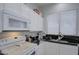 White kitchen with black countertops and stainless steel appliances at 4329 E Swilling Rd, Phoenix, AZ 85050