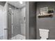 Bathroom featuring a glass-enclosed shower, toilet, and dark gray walls at 4542 W Villa Theresa Dr, Glendale, AZ 85308