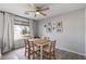 Light-filled dining room with a wooden table, neutral chairs, a ceiling fan, and a window view at 4542 W Villa Theresa Dr, Glendale, AZ 85308